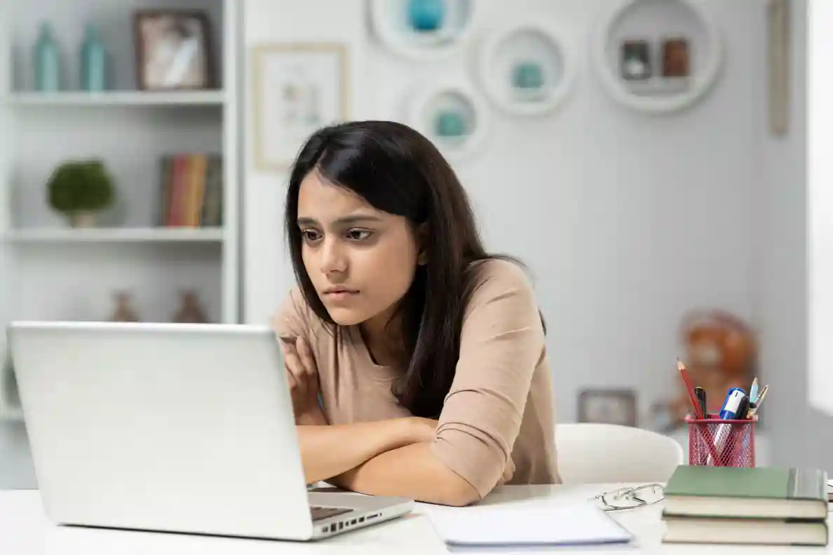 A woman studies a laptop screen