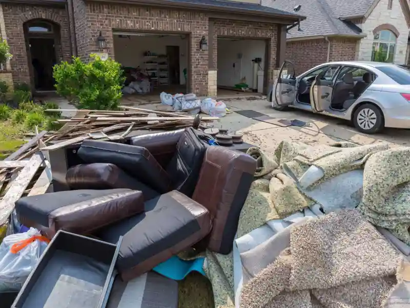 Flood damaged furniture sitting outside of a house on the curb.