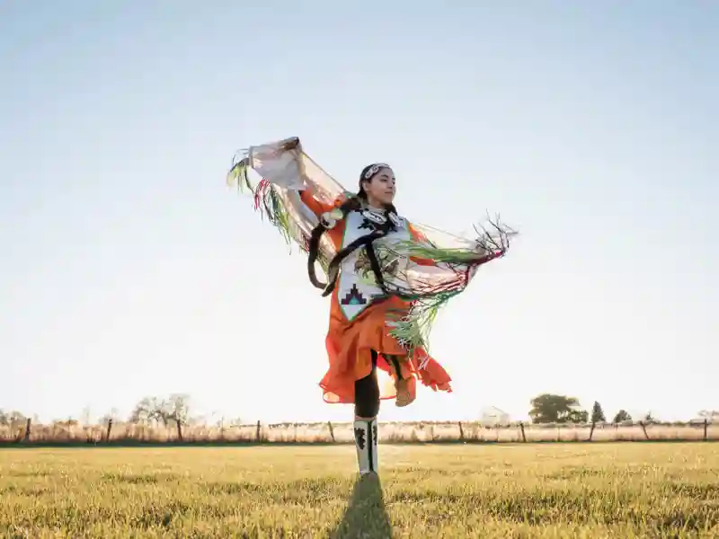 Indigenous person dancing in an open field
