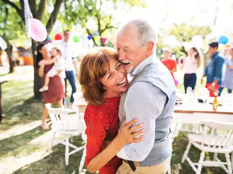 A senior couple dancing on a garden party outside in the backyard.