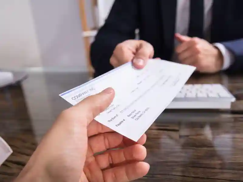 Manager handing an employee a paycheck.