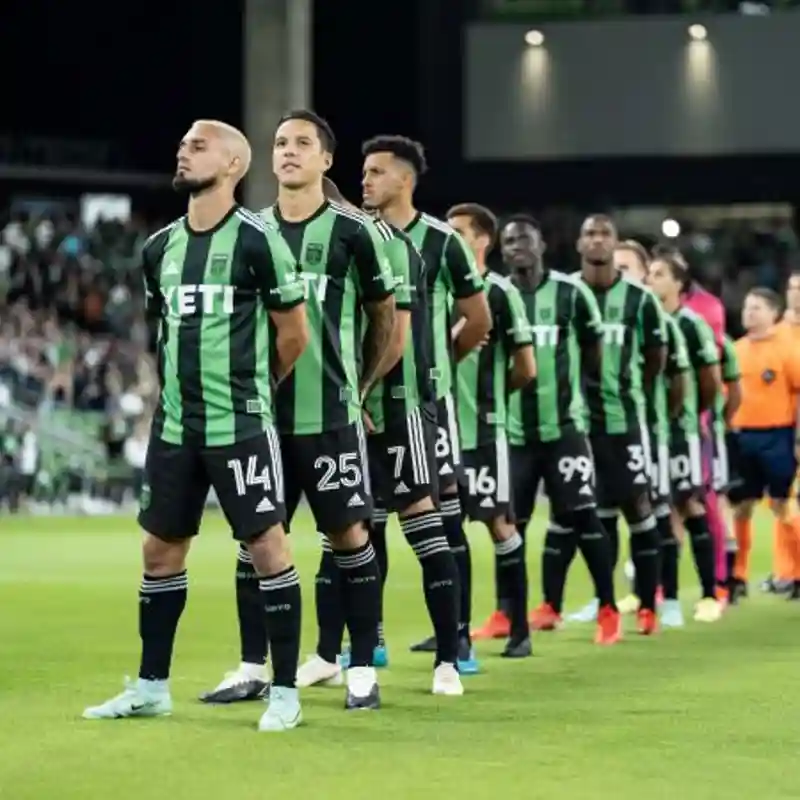 Austin FC players standing on a soccer field.