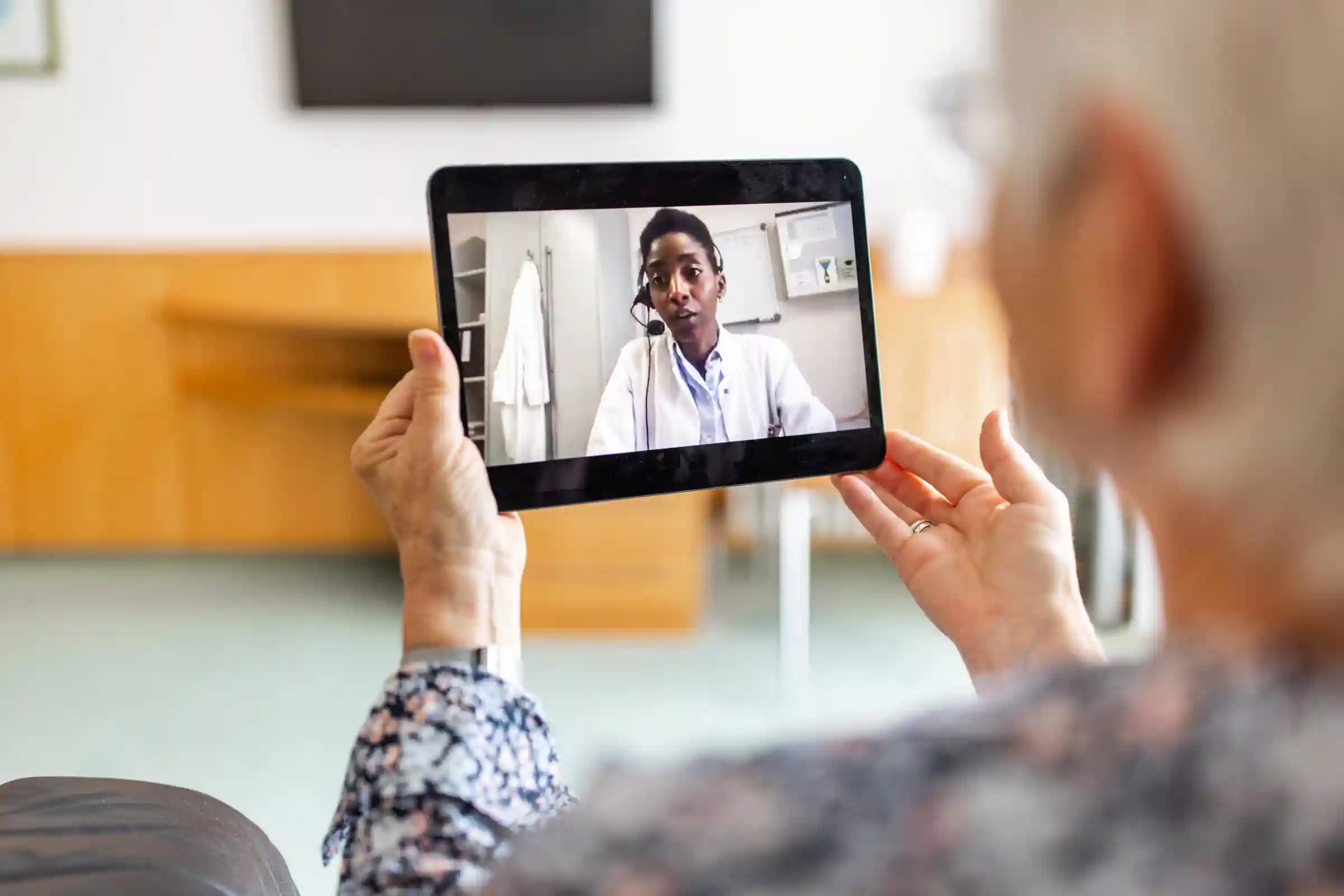 A woman uses a tablet for a telemedicine call