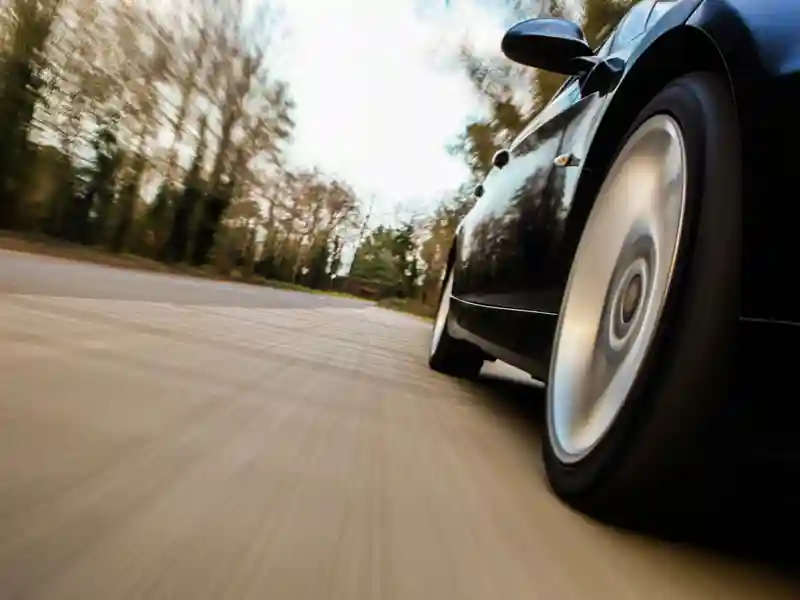 a car driving down a wooded road