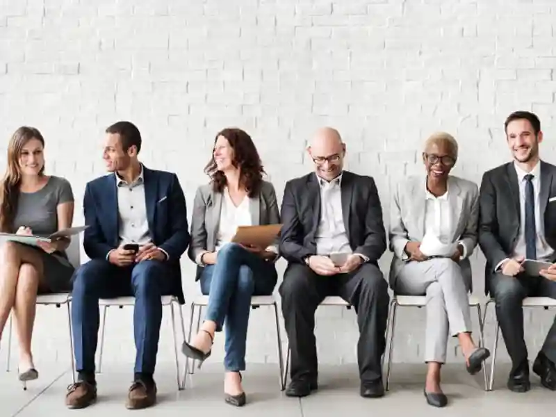 People sitting in a row smiling at each other