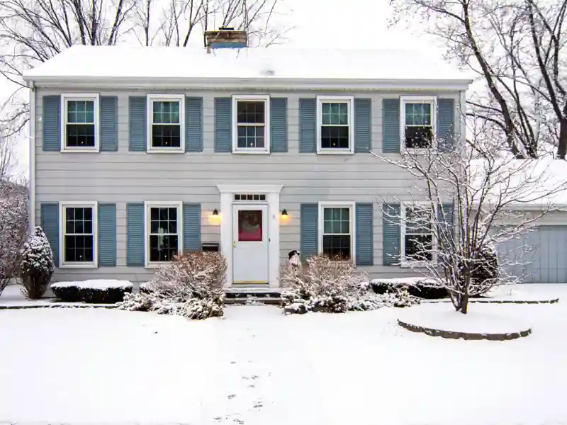 Large, two-story house with snow on the ground.
