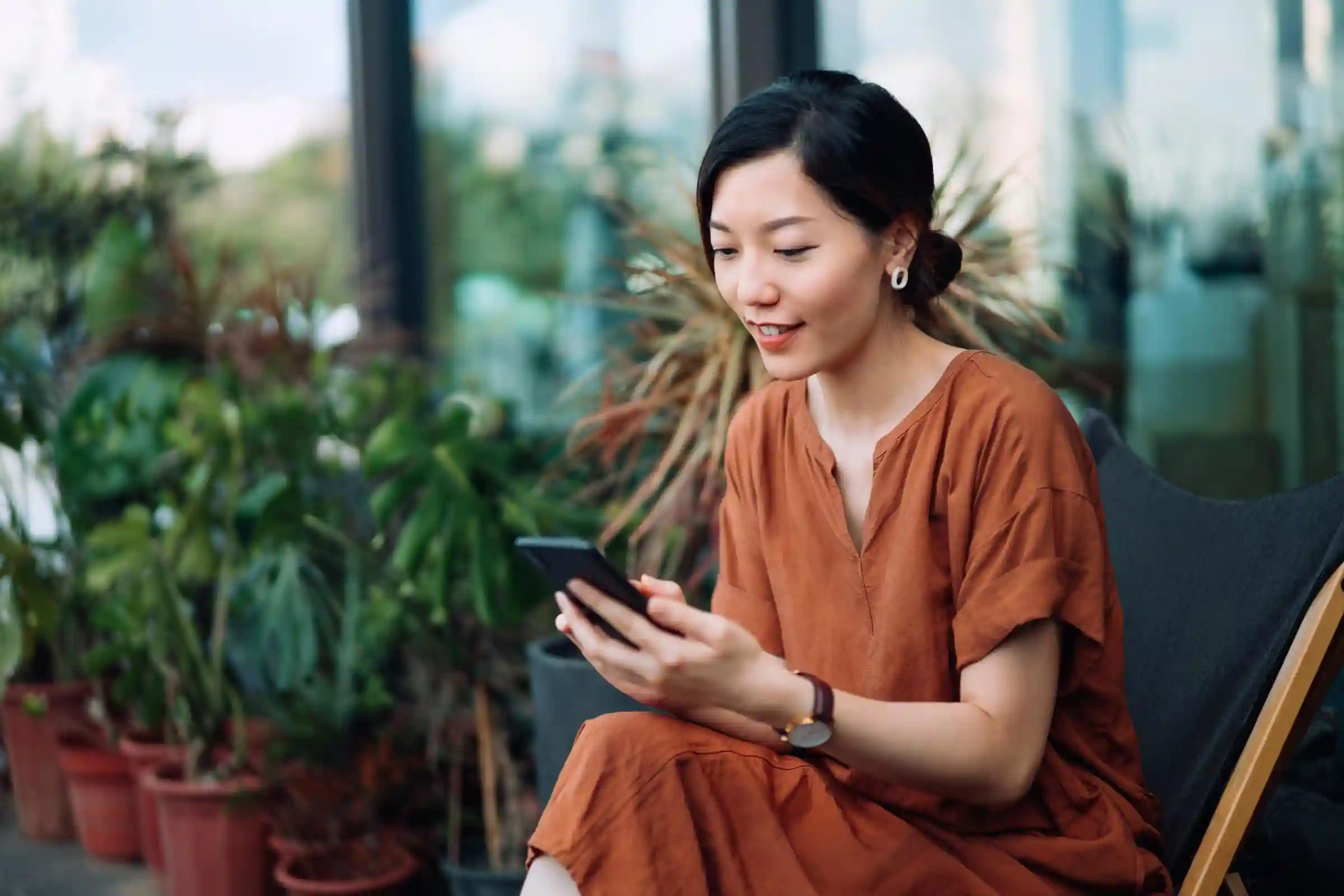 A woman looks at a phone in a nursery