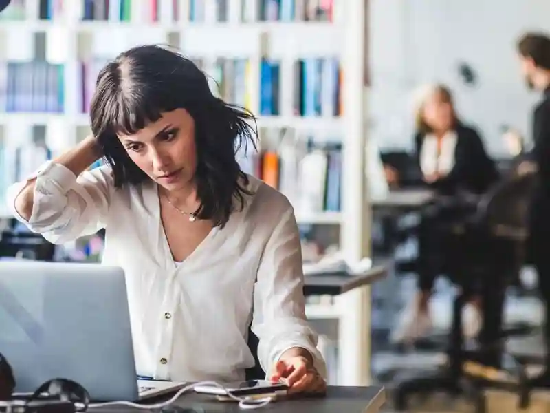 woman scratching her head confused at her computer