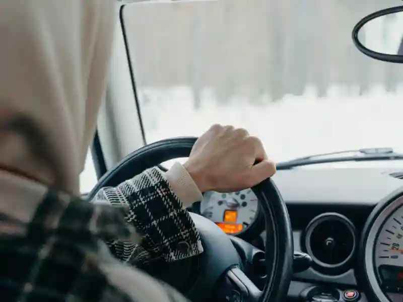 View from backseat of a man driving a car.