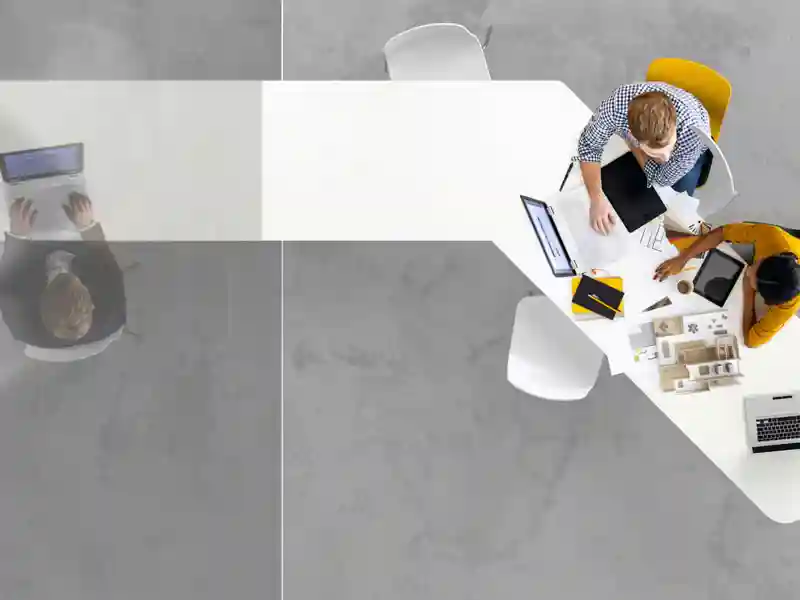 View from above of people working on computers at a desk